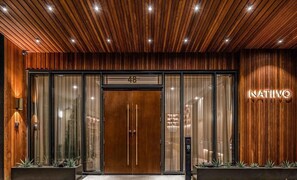 A hotel entrance with a wooden facade, a glass door with a number '48' above it, and a sign that reads 'NATIVO'. - NEW-Unique Hotel Vibes with Rooftop Pool near Downtown/Rainey St-Pet Friendly (Austin)
