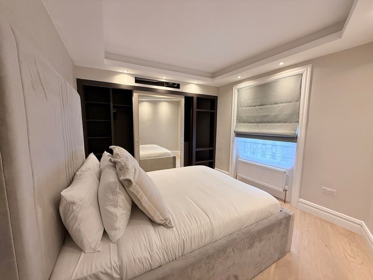 A bedroom with a bed, built-in closet, and a window with a view.