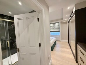 Ein Schlafzimmer mit Bett, Kleiderschrank und einer Duschkabine aus Glas.