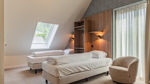 Ein Schlafzimmer mit zwei Betten, einem Oberlicht, einem Einbauschrank und einer Sitzecke.