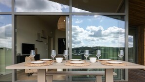 A dining table set with plates, glasses, and a bowl on a balcony with a view of the sky and mountains. - Delightful holiday home with free view. (Wissenkerke)