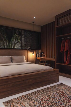 A modern bedroom with a wooden bed frame, a bedside table with a lamp, a wardrobe, and a patterned rug. - Romantic 1BR Villa Canggu Pool & Sunset Balcony (Canggu)