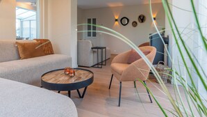 Ein modernes Wohnzimmer mit einer Couch, einem Sessel und einem Couchtisch.