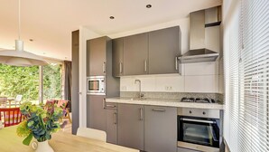 Eine moderne Küche mit grauen Schränken, einer Mikrowelle, einem Herd und einem Backofen.