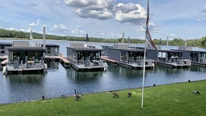Een jachthaven met drijvende huizen, elk voorzien van terras en uitzicht op het water.