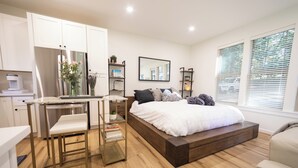 Ein modernes Schlafzimmer mit Bett, Nachttischen, Schreibtisch und Stuhl.