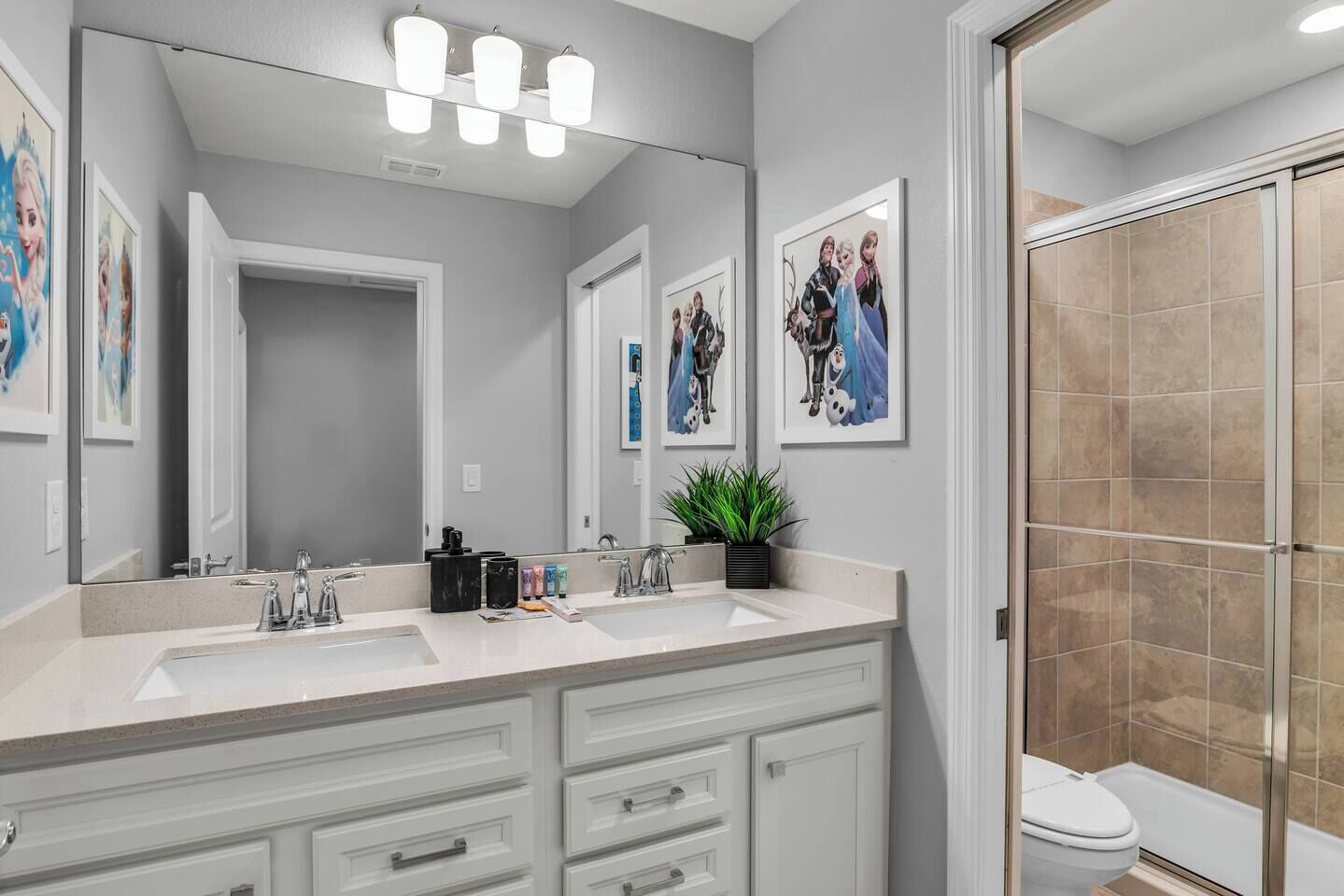 A modern bathroom with dual sinks, a large mirror, and a shower area.
