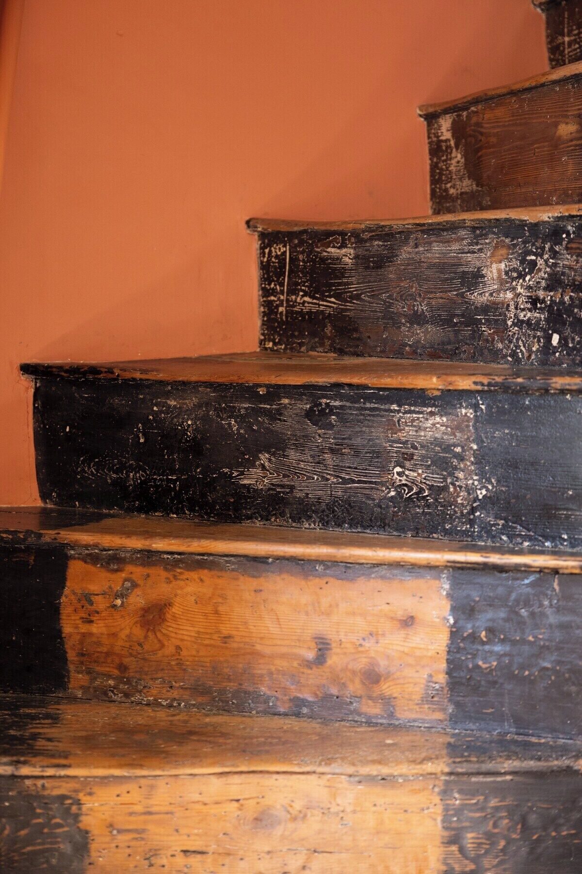 Eine Treppe mit mehreren Stufen, jede mit einer dunklen, verwitterten Oberfläche.