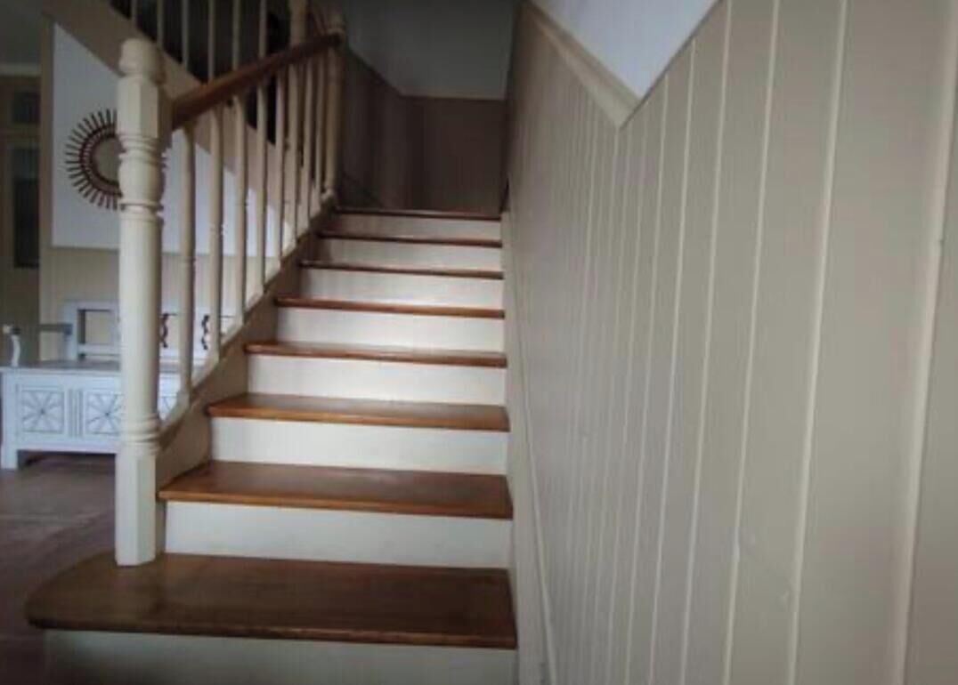 A staircase with wooden steps and white railings.