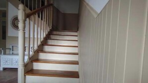 Eine Treppe mit Holzboden und weißen Geländern.