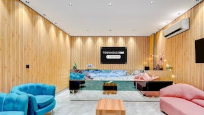 A modern reception area with a wooden wall, a sign reading 'TOWNHOUSE OAK,' and seating arrangements including blue and pink sofas. - Super Deluxe Roomtroy Resorts and Wellness (Dera Bassi)