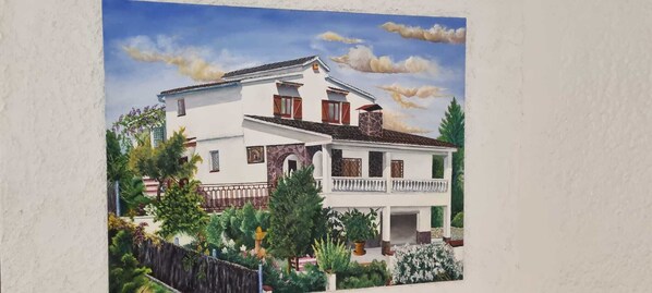 A two-story building with a balcony, surrounded by greenery and a fence. - Bed and Breakfast in a Charming Country House (Olivella)