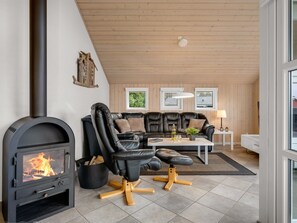 A cozy living room with a fireplace, leather sofa, and a view of the outdoors. - "Erikka" - 40km from the sea by Interhome (Ansager)