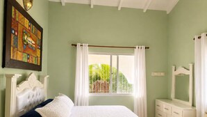 A bedroom with a bed, a dresser, a mirror, a window with curtains, and a painting on the wall. - Painted house- 4 pax, 4 min from the beach (Las Galeras)