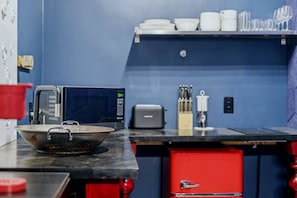 Eine Küche mit Mikrowelle, Toaster und einer roten Schublade.