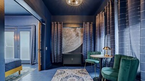 Una habitación con una cama, un escritorio, una silla, una alfombra y cortinas.