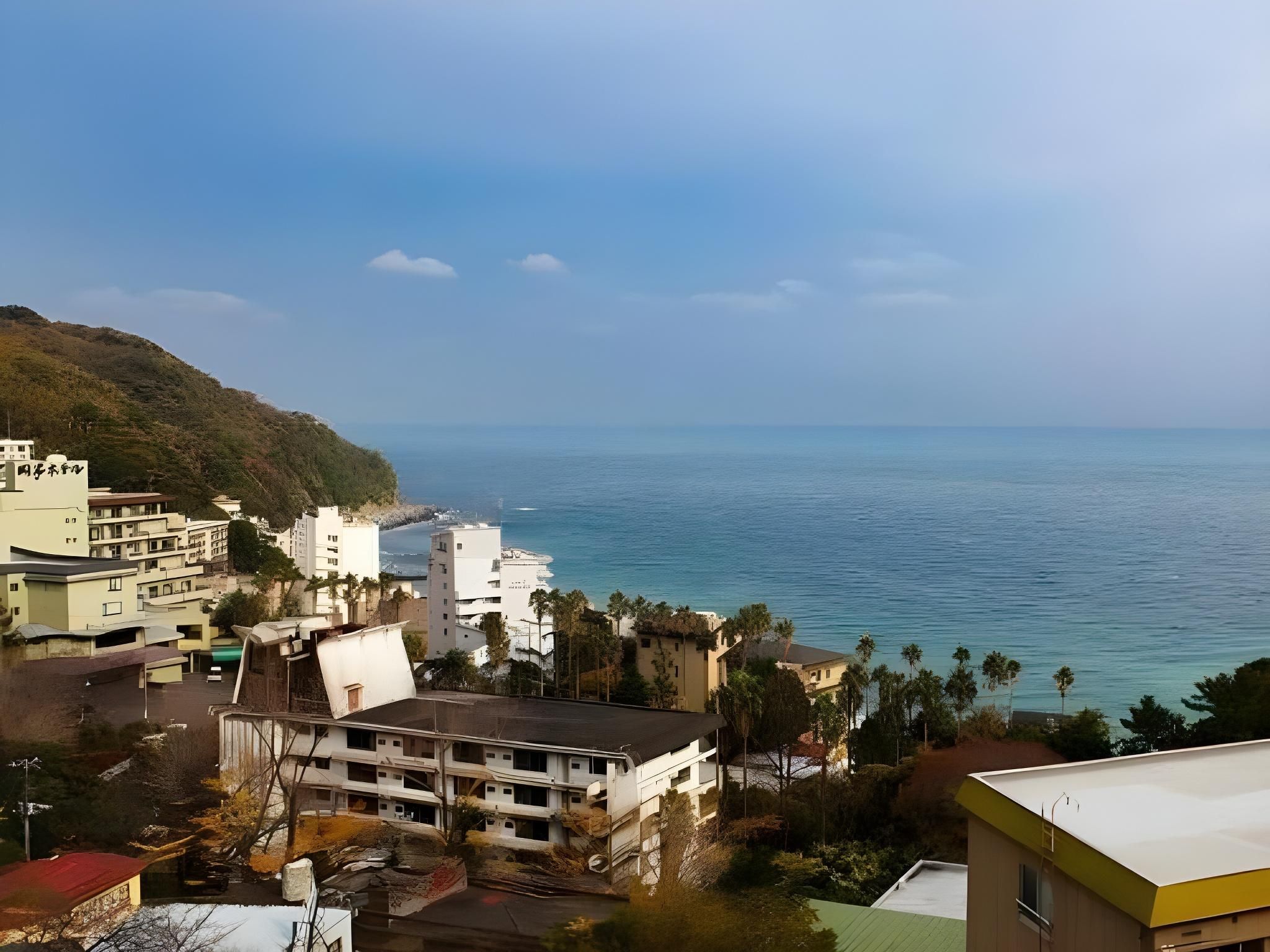 Paisagem urbana costeira com edifícios, uma praia e céu claro.