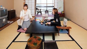 Une pièce de style japonais traditionnel, avec un sol recouvert de tatamis, une table basse et des portes coulissantes.