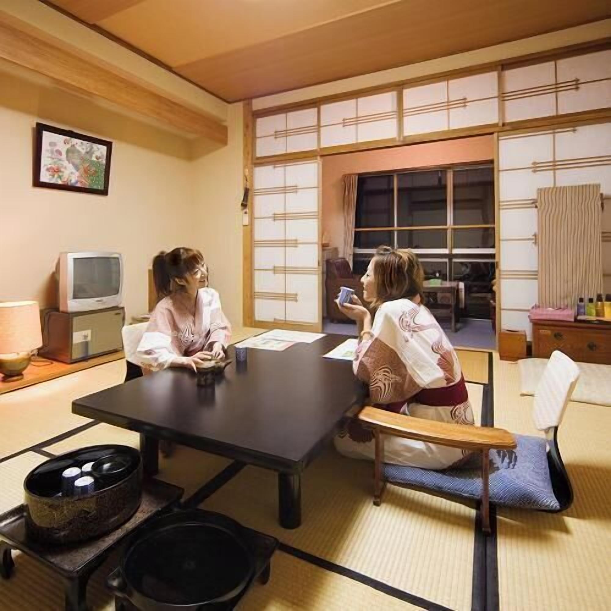 Ein traditioneller japanischer Raum mit Tatami-Boden, einem niedrigen Tisch und einer Schiebetür.