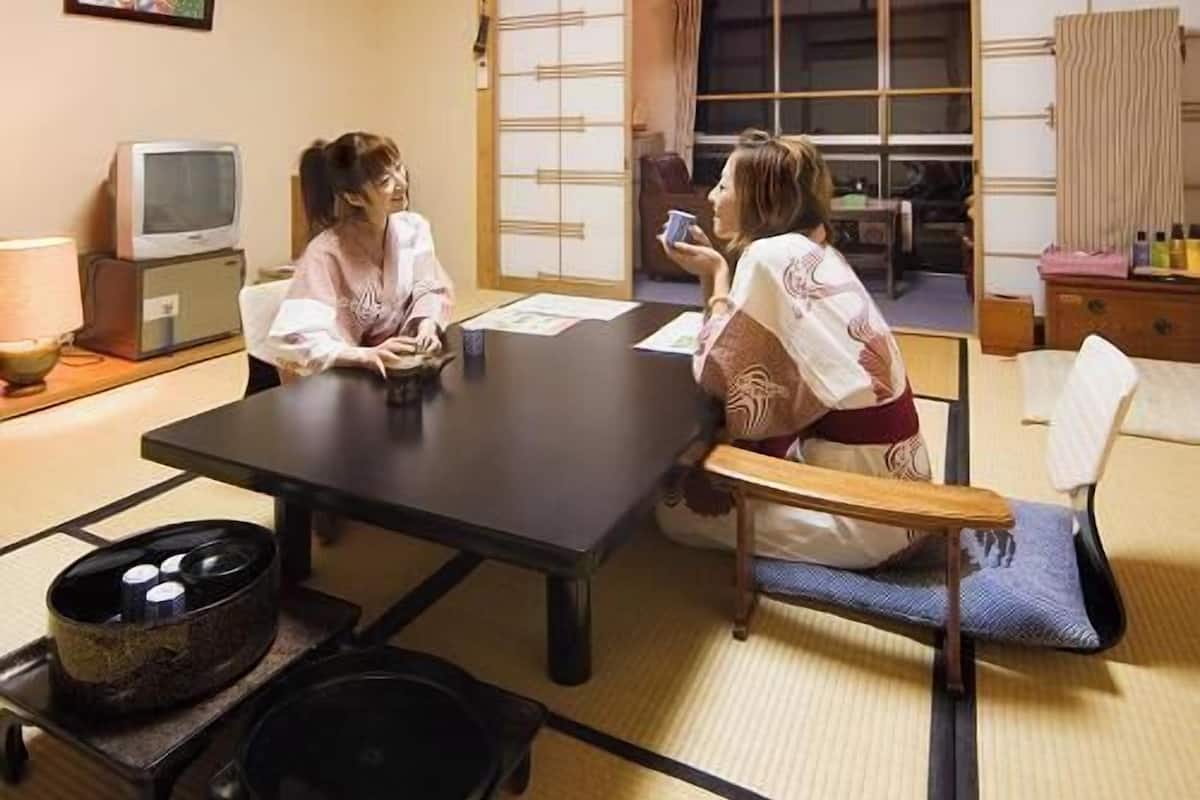 Een traditionele Japanse kamer met tatami vloerbedekking, een lage tafel en een schuifdeur.