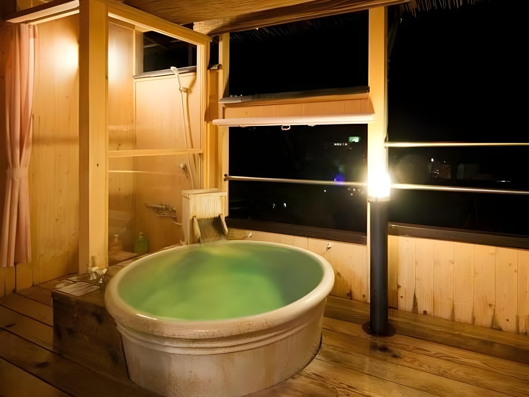 A wooden room with a hot tub and a window.