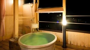 A wooden room with a hot tub and a window.