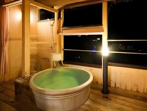 Een houten kamer met een bubbelbad en een raam.