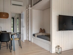 A room with a bed, a TV, a dining area with chairs, and a staircase. - "Emin" - 2.8km from the sea by Interhome (Henne)