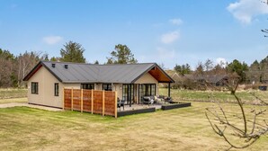 A modern house with a large deck, a fenced yard, and a clear sky. - "Emin" - 2.8km from the sea by Interhome (Henne)