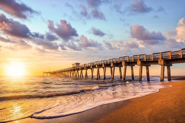 A pier extending into the ocean with a sunset in the background. - Daze Inn Between: lagoon pool mins to beaches (South Venice)