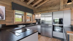 Una cocina moderna con vigas de madera, electrodomésticos de acero inoxidable y un amplio ventanal.