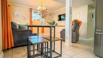 Un salon comprenant un canapé, une table basse, un téléviseur et un réfrigérateur.