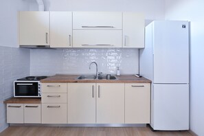 Una cocina compacta equipada con microondas, estufa, lavaplatos y refrigerador.