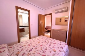 A bedroom with a bed, a wardrobe, a mirror, and an air conditioning unit. - ACV - Aguamarina-2ª linea planta 4 sur (OROPESA)