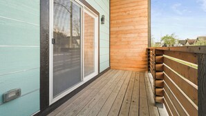 A wooden deck with a sliding glass door leading to a room with a view of the surrounding area. - New Indy Game House- Theater + Arcade - Sleeps 12 (Indianapolis)