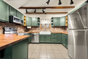 A kitchen with green cabinets, a stainless steel refrigerator, a microwave, and a dishwasher. - Poconos Country Getaway - Spacious home in Tobyhanna (Tobyhanna)