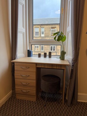 A corner room with a desk, a window, and a view of buildings. - Stylish Edinburgh Stay | Fast Wi-Fi & Parking (Edinburgh)