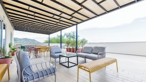 An outdoor seating area with a covered patio, a sofa, a bench, and a table. - Casa Curie (Monterrey)