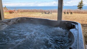 Un jacuzzi con vista al océano y a un árbol.