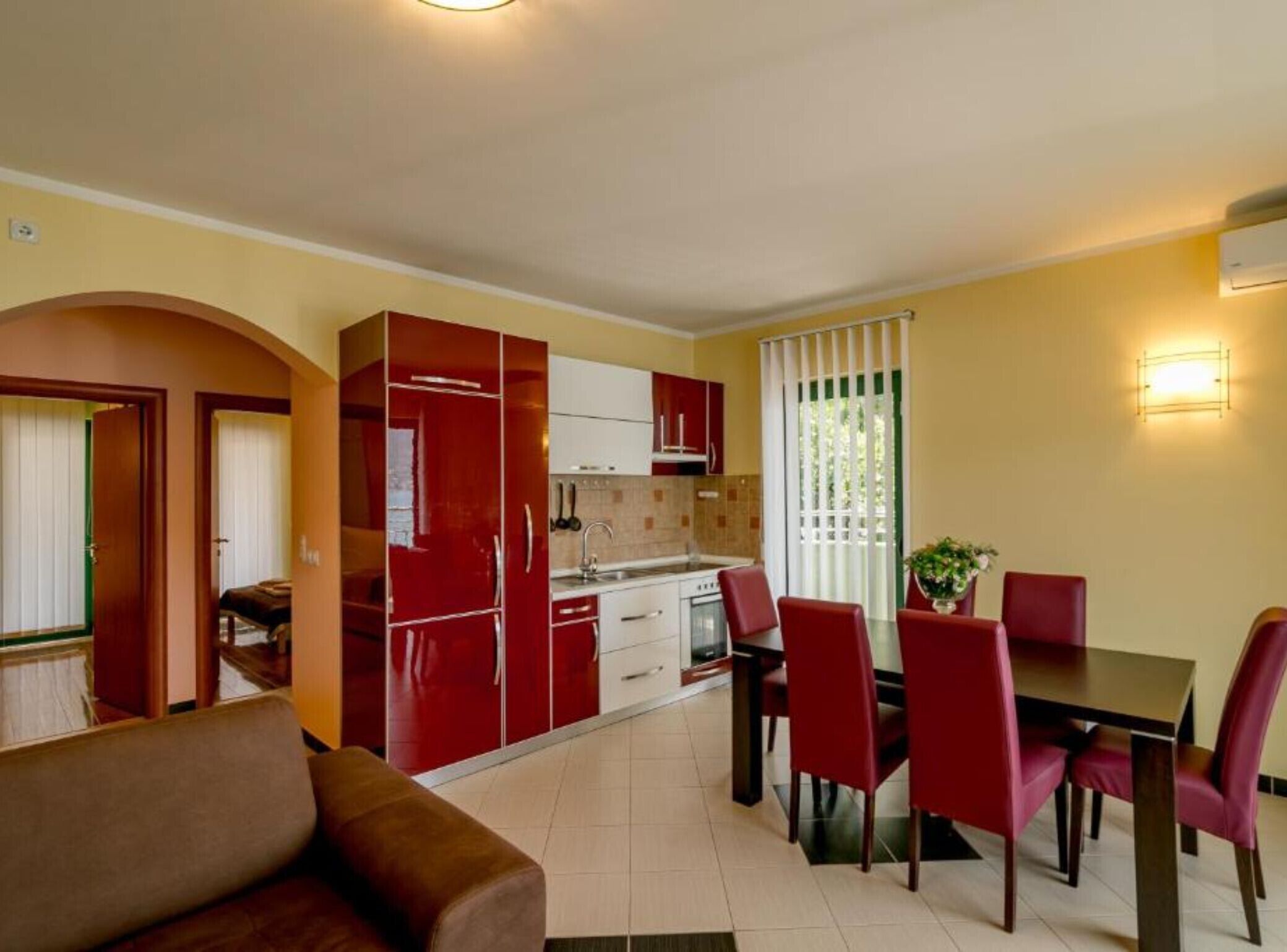 A compact living space with a kitchenette, dining area, and a sofa.