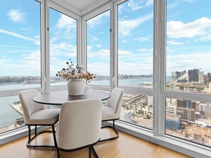 A modern room with large windows, a round table, and four chairs.