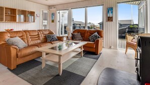 A spacious living area with a brown leather sofa, a wooden coffee table, and a balcony with a grill. - "Danail" - 250m from the sea by Interhome (Juelsminde)