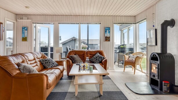 A modern living room with a leather sofa, a wooden coffee table, and a fireplace. - "Danail" - 250m from the sea by Interhome (Juelsminde)