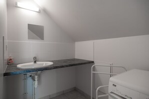 Un bagno con lavandino bianco, uno specchio e un water bianco.