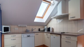 Una cocina moderna con tragaluz, lavavajillas y electrodomésticos integrados.