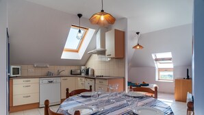 Una cocina moderna con comedor, tragaluces y vistas al exterior.