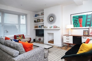 A modern living room with a sofa, coffee table, and a fireplace. - Artistic 1BDR Townhome | Central Brighton (Brighton and Hove)