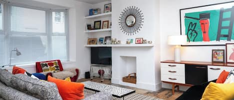 A modern living room with a sofa, coffee table, and a fireplace.