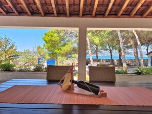 A covered outdoor seating area with a table, chairs, and a view of the sea. - Vacation home Blue by Interhome (Drvenik Mali)