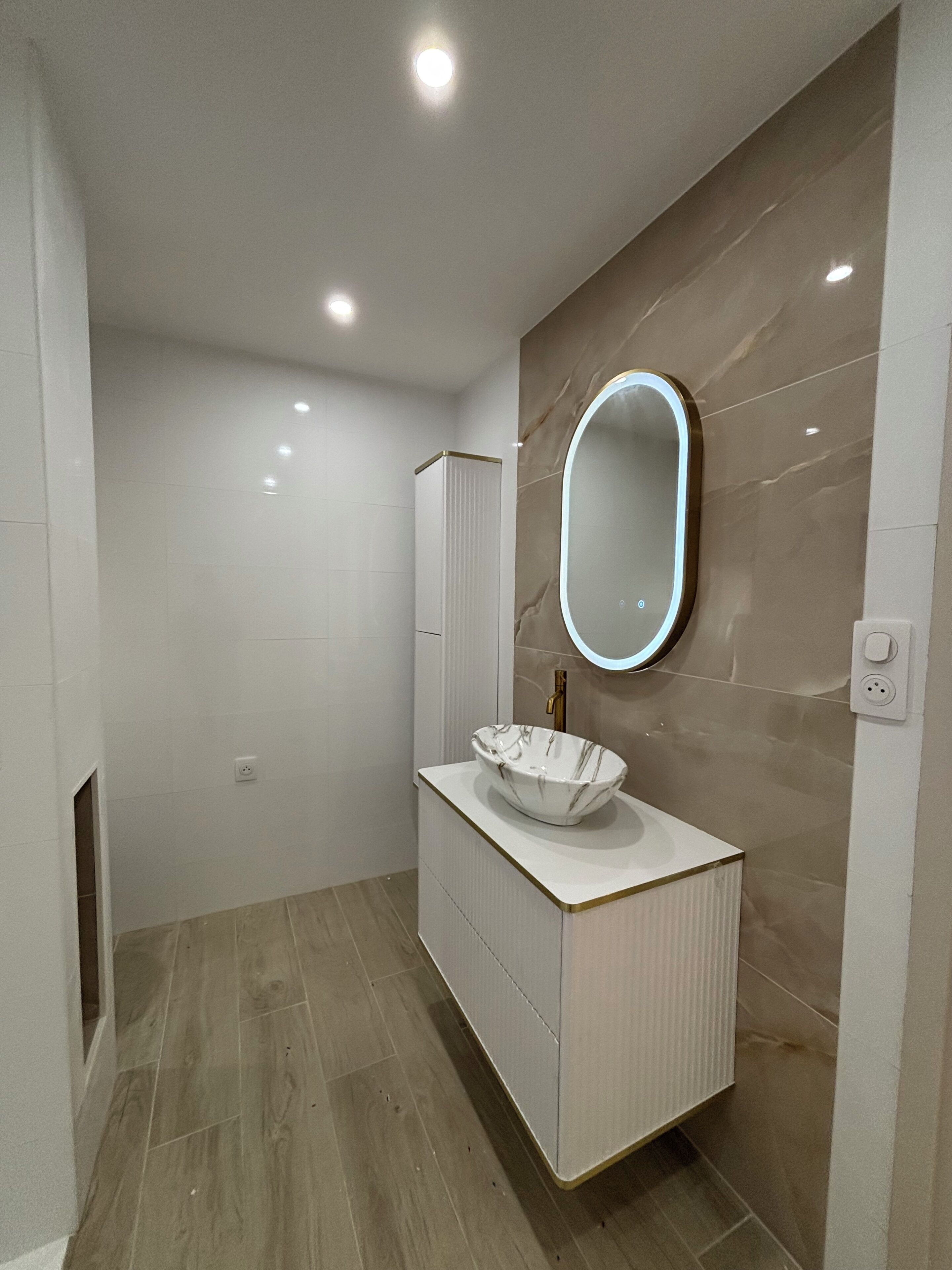 A modern bathroom with a vanity, a mirror, and a light fixture.